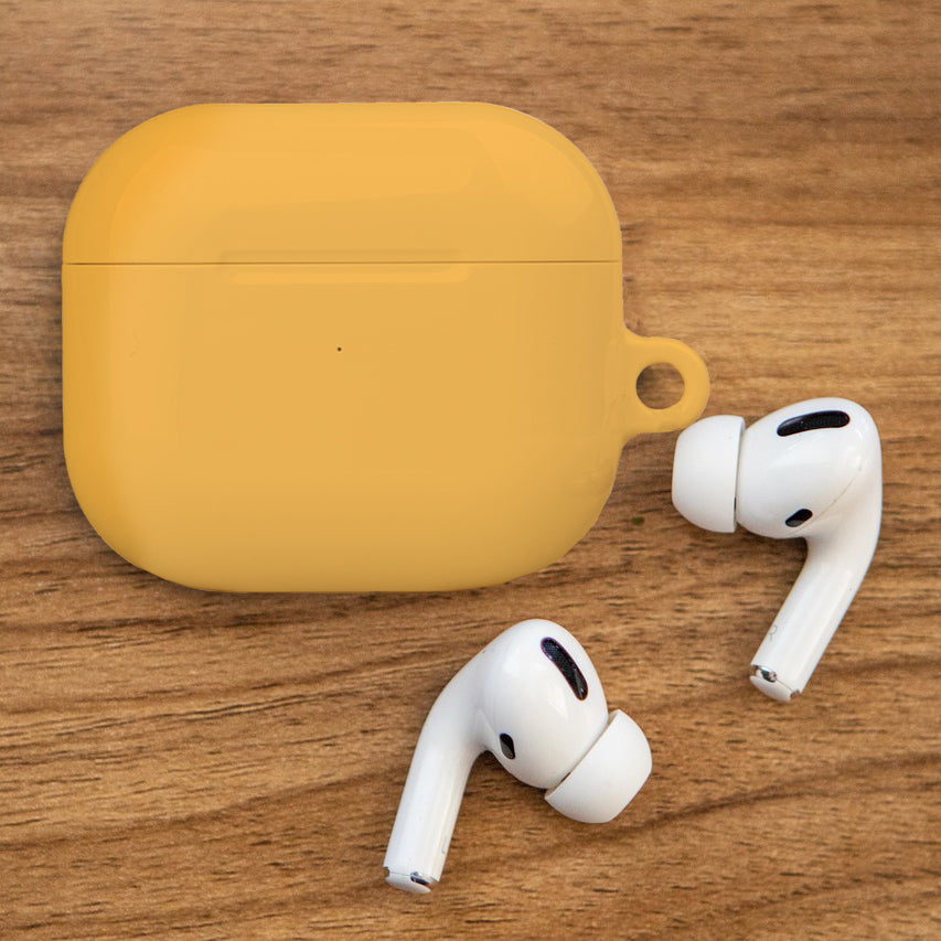 Yellow AirPods case on a wooden table 