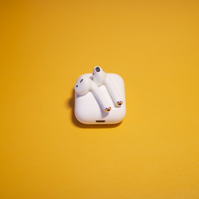 White Apple AirPod Earphones on a Yellow background