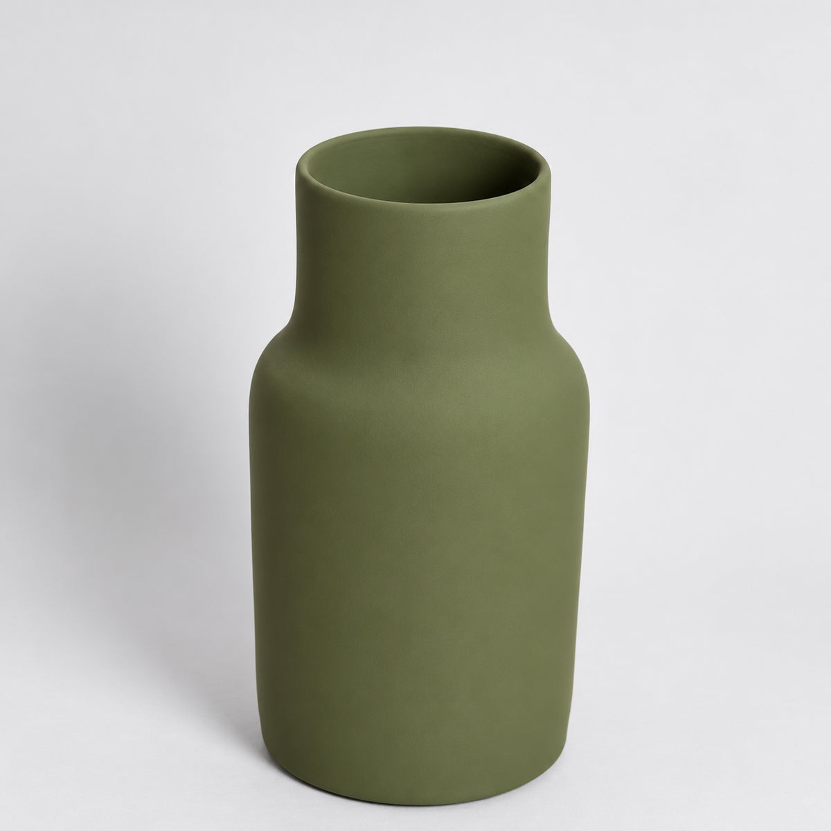 A matte olive green ceramic vase with a cylindrical body and a short neck, shown on a light gray studio background.