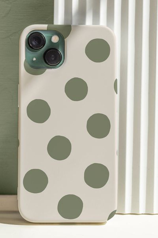 Phone case with green polka dots on a neutral background