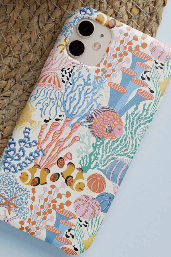 Phone case with ocean-themed design featuring fish and coral on a blue background