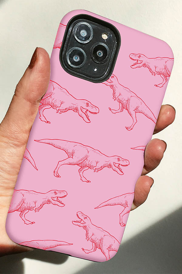 Hand holding a pink phone cause with a red line art t-rex design on it 