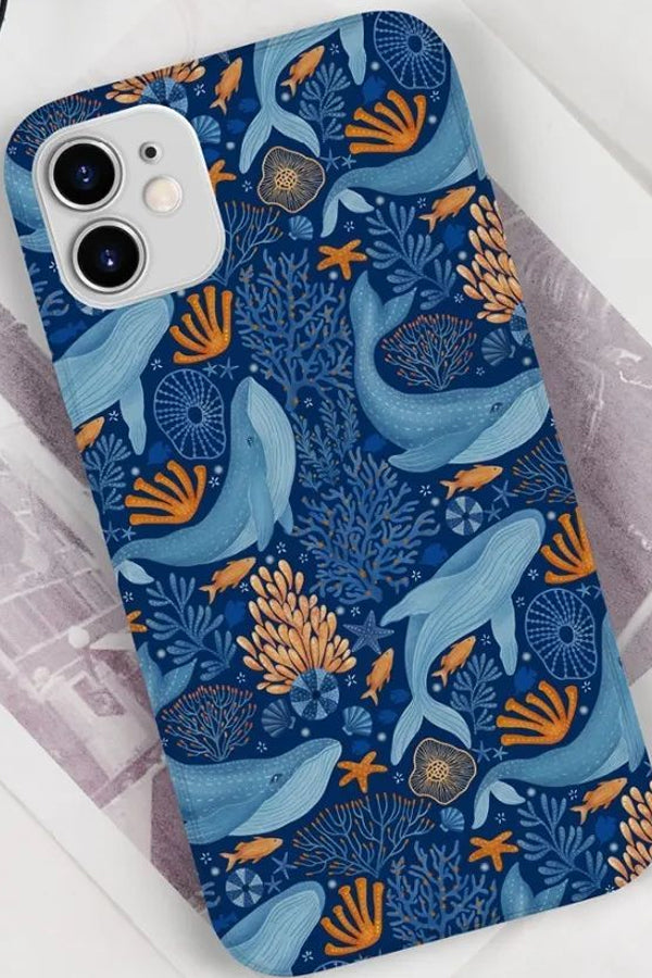 Phone case with blue whale and coral design on a white surface