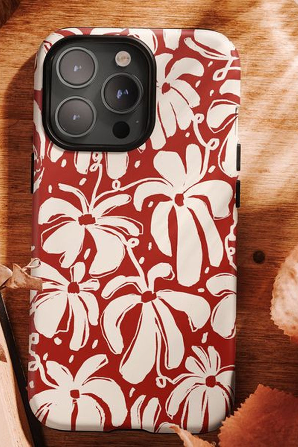 Phone case with red and white floral pattern on a wooden surface