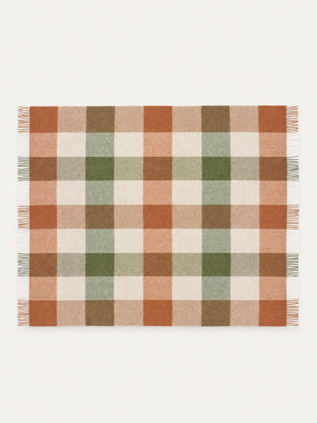 A rectangular plaid blanket with fringe on the left and right edges, featuring a checkered pattern in terracotta orange, sage green, olive brown, and cream on a white background.