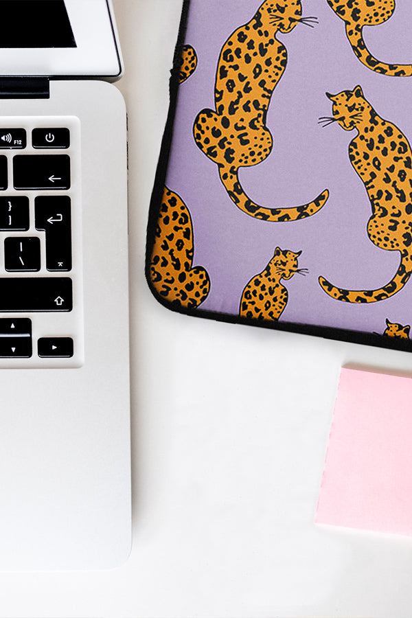 Laptop with a leopard print sleeve on a white surface