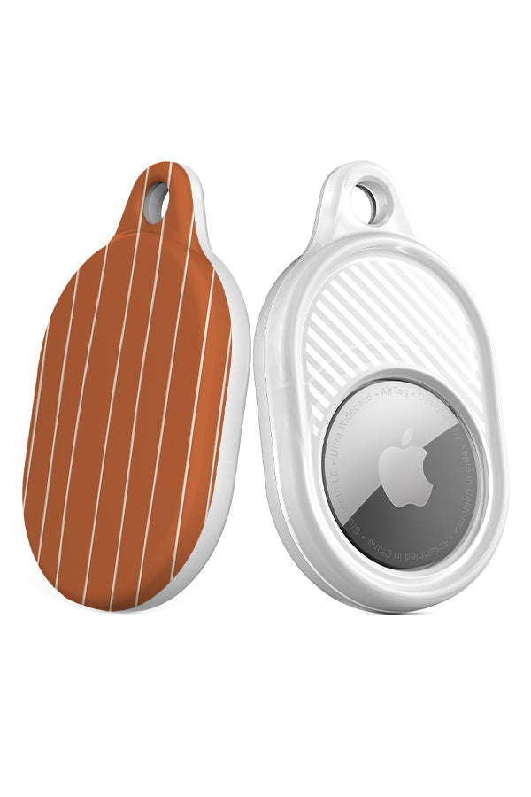 fine line AirTag case angle view with a burnt orange base and thin hand drawn white stripes