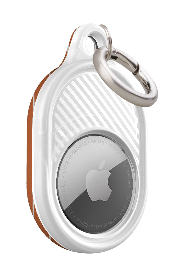 fine line AirTag case front view with a burnt orange base and thin hand drawn white stripes