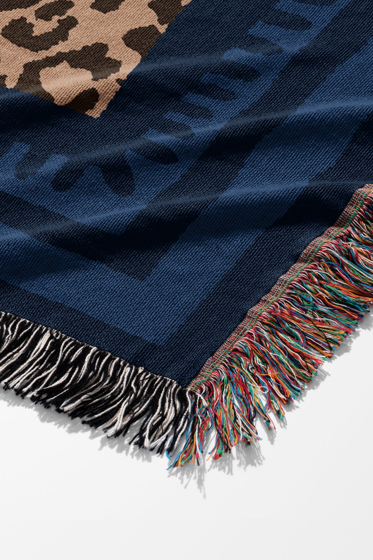 The resting panther jacquard woven throw corner close up with a blue geometric border and colourful frindge